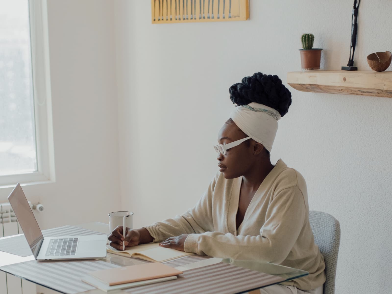 A woman reflecting with a notebook during an online formation session